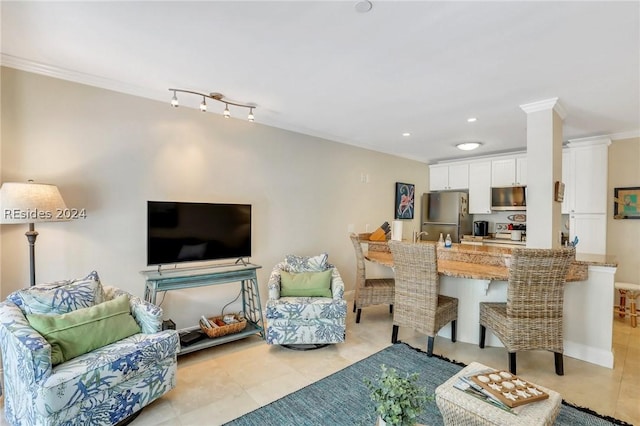 tiled living room with crown molding and decorative columns