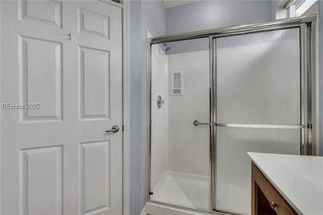 bathroom with vanity and a shower with door