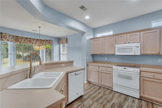 kitchen featuring light brown cabinetry, sink, white appliances, and decorative light fixtures