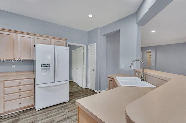 kitchen featuring light brown cabinetry, sink, light hardwood / wood-style flooring, and white fridge with ice dispenser