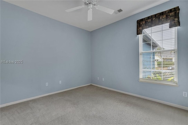 empty room featuring ceiling fan and carpet