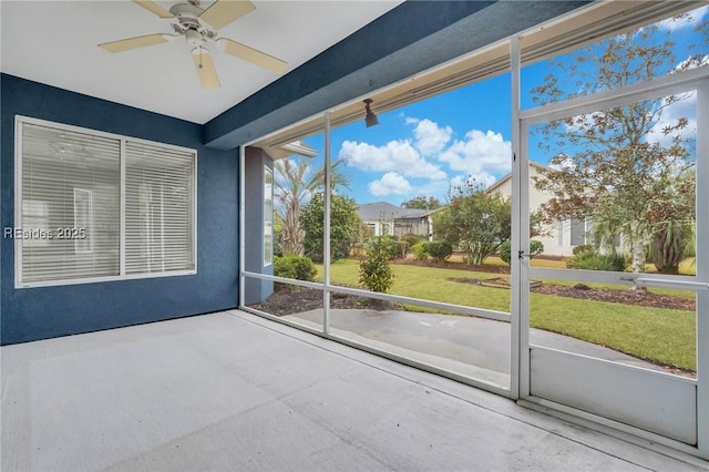 unfurnished sunroom with ceiling fan and a wealth of natural light