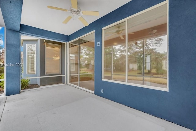 unfurnished sunroom with ceiling fan