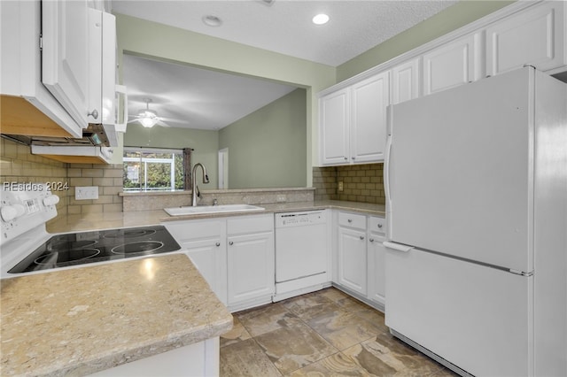 kitchen featuring white cabinetry, sink, white appliances, and kitchen peninsula