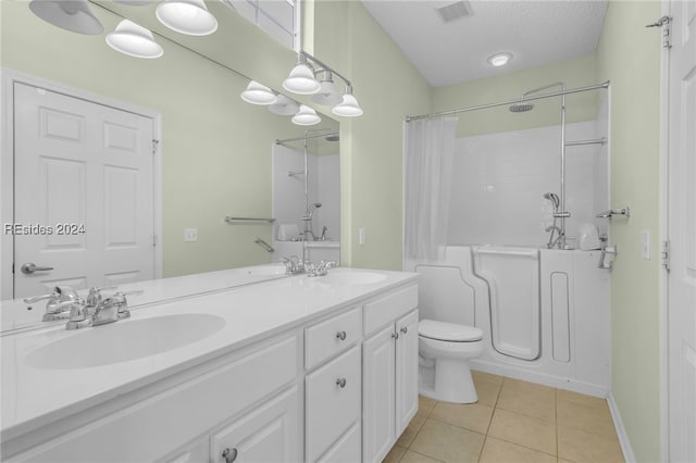 full bathroom with shower / tub combo with curtain, vanity, toilet, tile patterned floors, and a textured ceiling