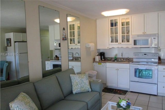 kitchen with sink, white appliances, light tile patterned floors, and white cabinets