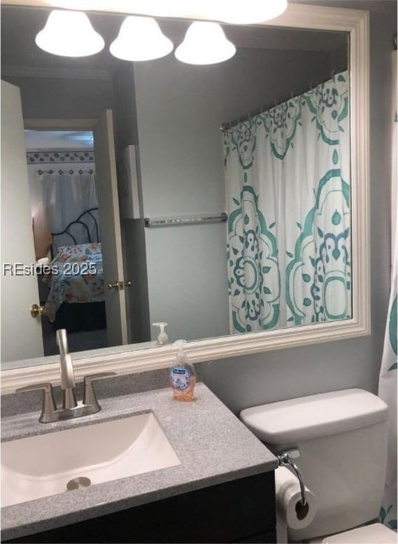 bathroom with vanity, ornamental molding, and toilet