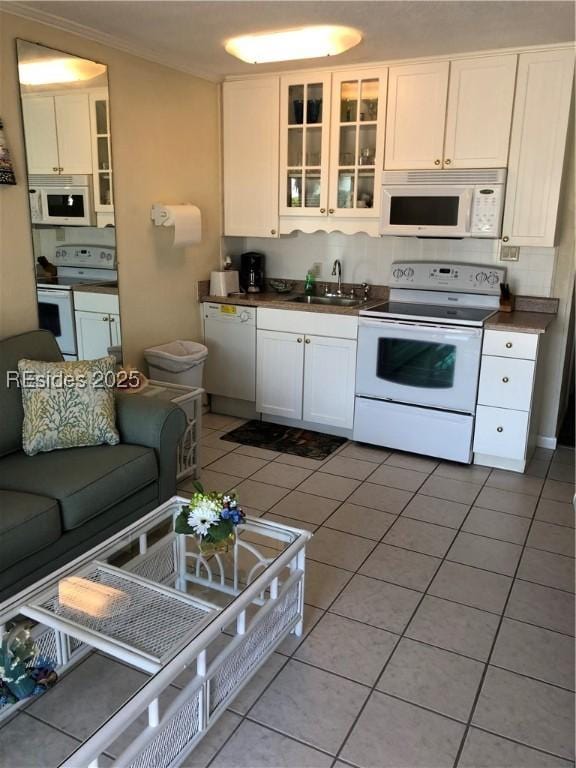 kitchen with white cabinetry, white appliances, light tile patterned flooring, and sink