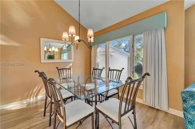 dining space featuring an inviting chandelier, light hardwood / wood-style flooring, and lofted ceiling