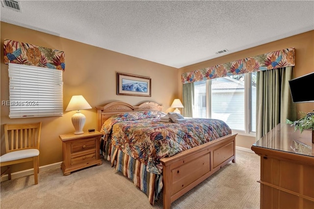 bedroom featuring light colored carpet and a textured ceiling