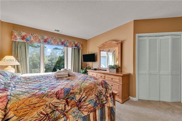 bedroom featuring light colored carpet, a closet, and a textured ceiling