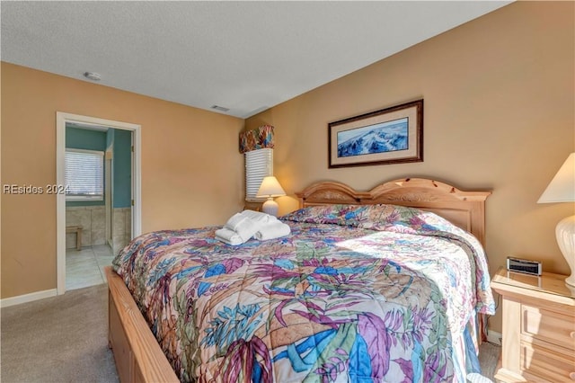 bedroom featuring ensuite bath and light colored carpet