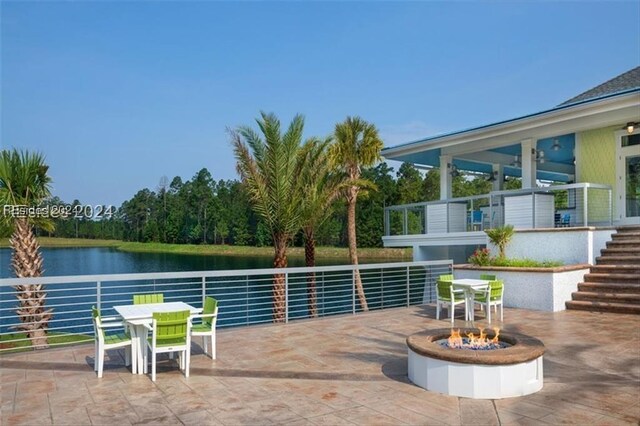 view of pool featuring a patio area, a water view, and an outdoor fire pit