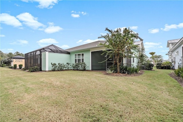 rear view of property with a lanai and a yard