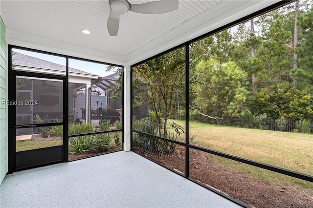 unfurnished sunroom with ceiling fan