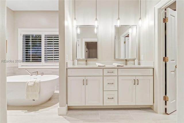 bathroom featuring vanity, a bath, and tile patterned floors