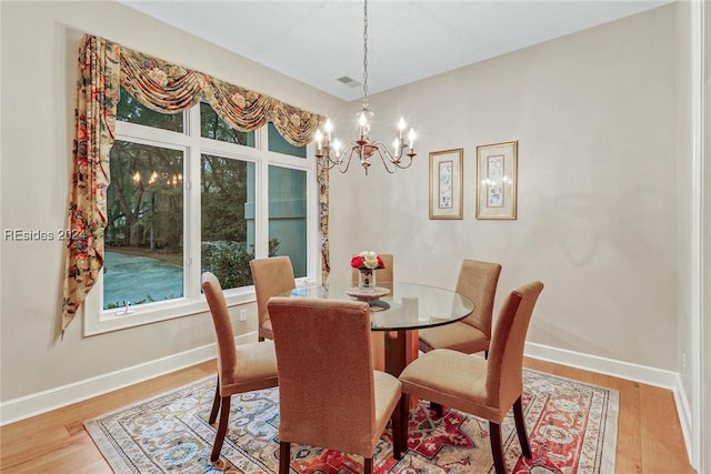 dining area with a chandelier and light wood-type flooring