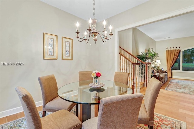 dining area with wood-type flooring and a notable chandelier