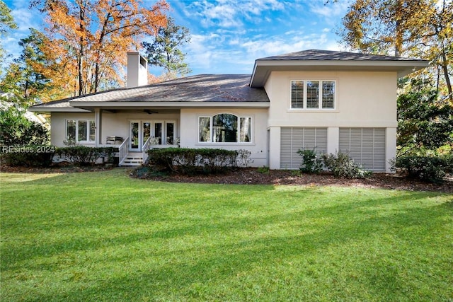 rear view of house with a lawn and ceiling fan