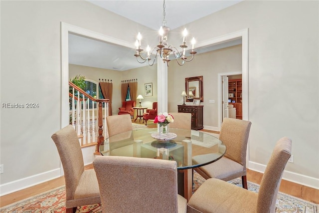 dining area featuring wood-type flooring and a chandelier