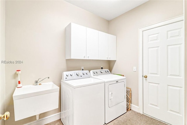 laundry room featuring light carpet, sink, washing machine and dryer, and cabinets