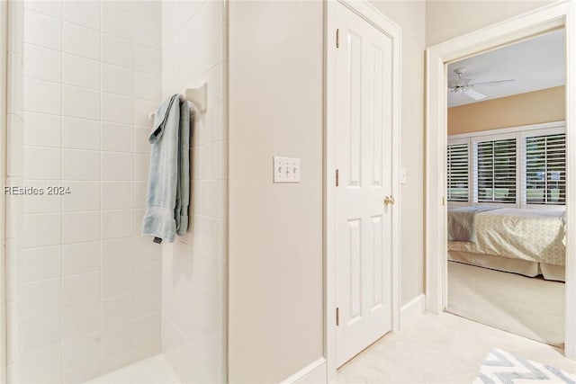 bathroom with a tile shower and ceiling fan