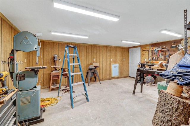 misc room with concrete flooring and wood walls