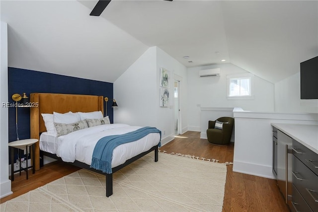 bedroom with hardwood / wood-style flooring, ceiling fan, vaulted ceiling, and an AC wall unit