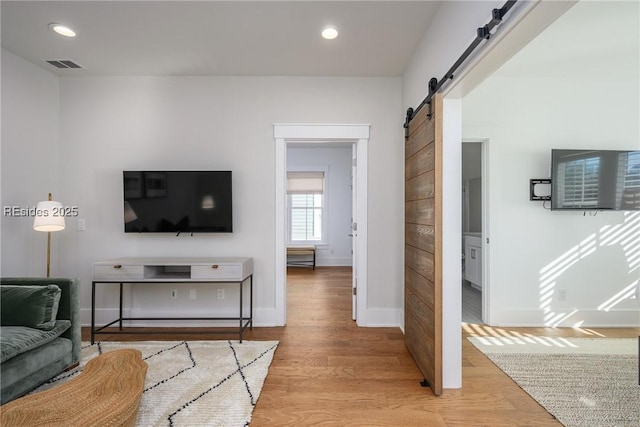 living room featuring light hardwood / wood-style flooring and a barn door