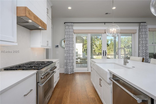 kitchen with sink, white cabinetry, dark hardwood / wood-style flooring, pendant lighting, and stainless steel appliances