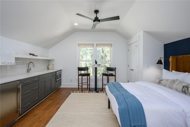 bedroom with ceiling fan, lofted ceiling, sink, and hardwood / wood-style floors