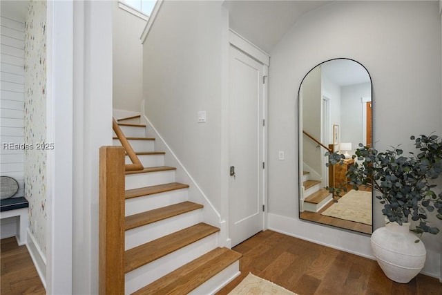 stairway featuring hardwood / wood-style flooring and vaulted ceiling