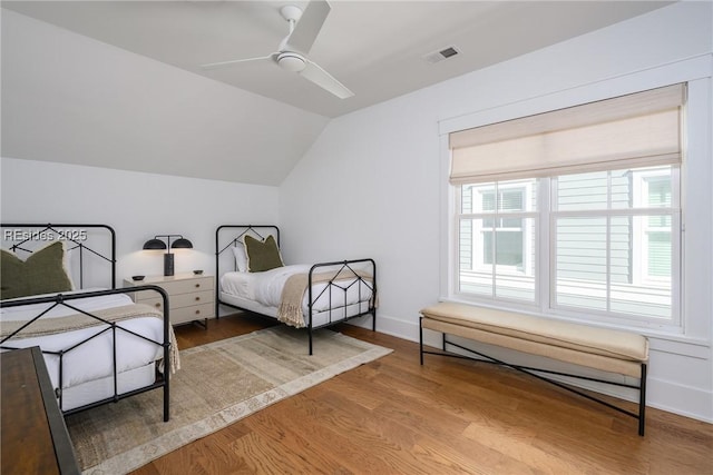 bedroom featuring hardwood / wood-style flooring, ceiling fan, lofted ceiling, and multiple windows