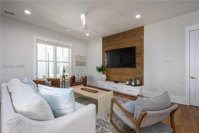 living room with dark wood-type flooring and ceiling fan