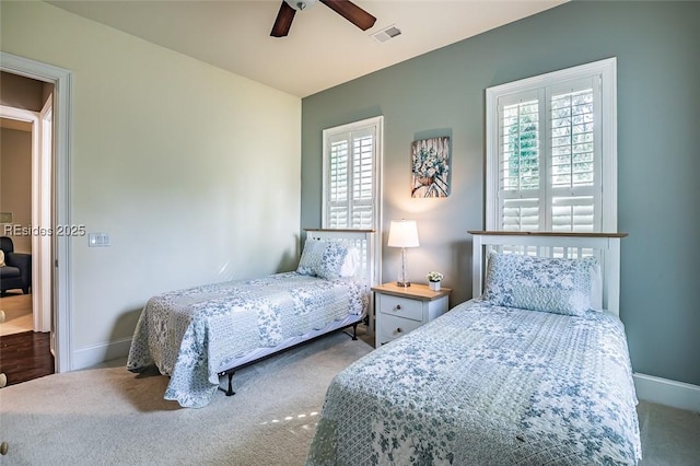 carpeted bedroom with multiple windows and ceiling fan