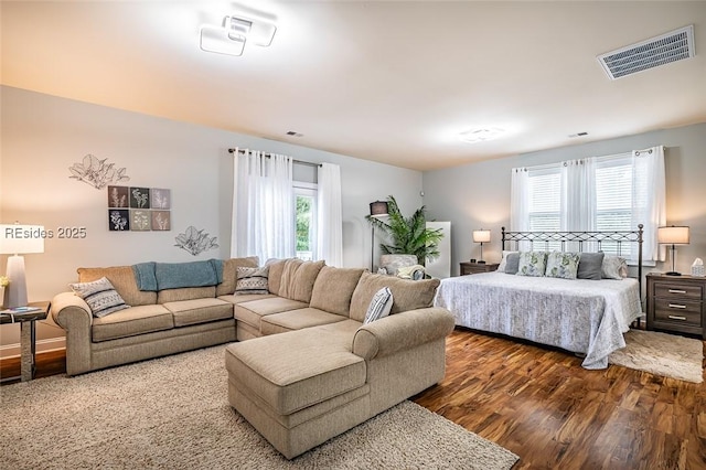 bedroom featuring multiple windows and dark hardwood / wood-style flooring