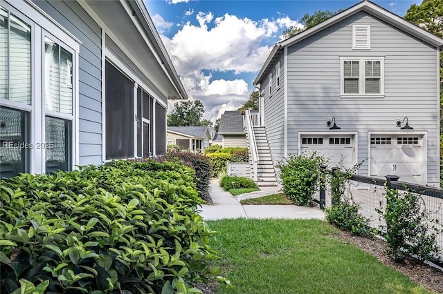 view of side of property with a garage and a lawn