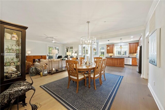 dining area with ornamental molding, light hardwood / wood-style floors, and a chandelier