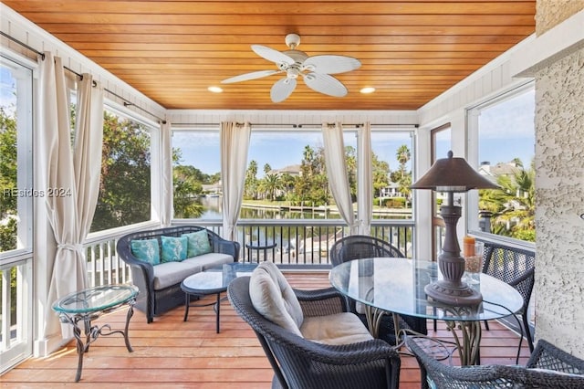 sunroom featuring wooden ceiling, ceiling fan, and a water view