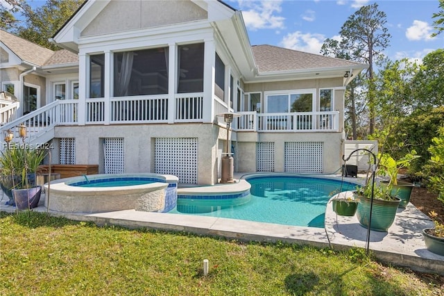 rear view of house featuring a swimming pool with hot tub and a sunroom