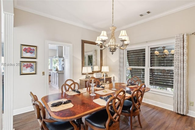 dining space featuring crown molding, dark hardwood / wood-style floors, and an inviting chandelier