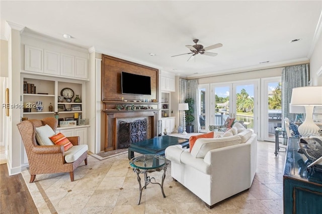 living room with crown molding, ceiling fan, built in features, and french doors