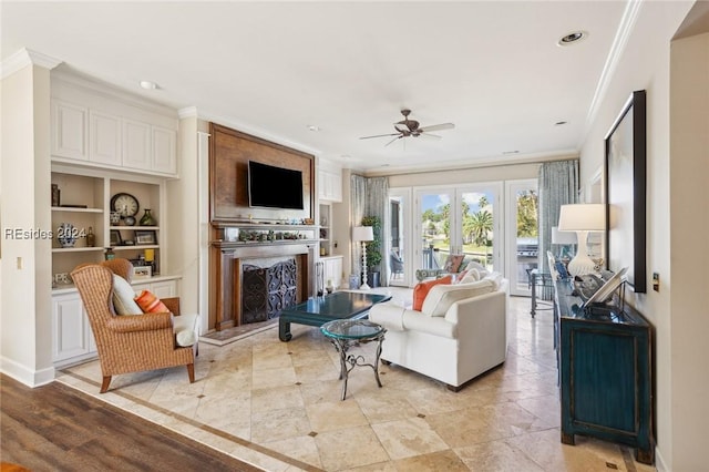 living room with crown molding, ceiling fan, and built in shelves