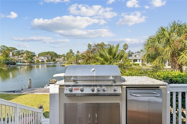 view of patio / terrace featuring area for grilling, an outdoor kitchen, and a water view