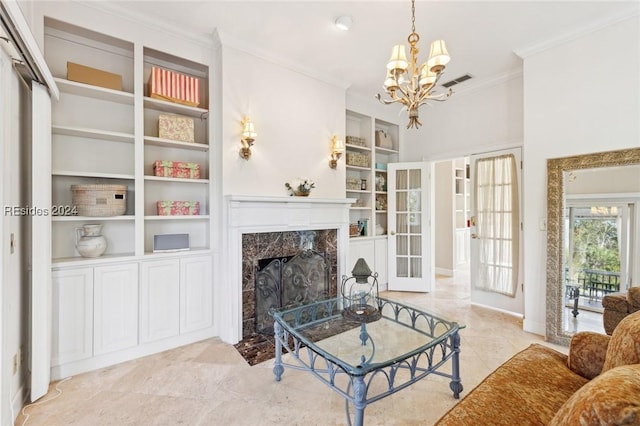 living room featuring french doors, crown molding, a chandelier, built in features, and a premium fireplace