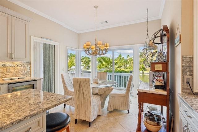 tiled dining room featuring wine cooler, crown molding, and an inviting chandelier