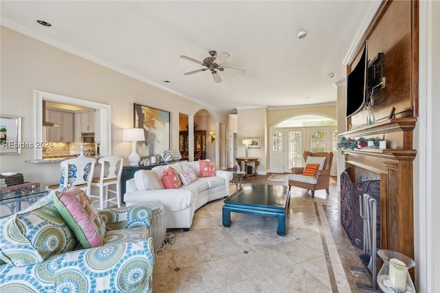 living room featuring crown molding and ceiling fan