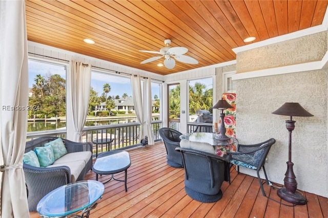 sunroom / solarium featuring ceiling fan, a water view, and wood ceiling