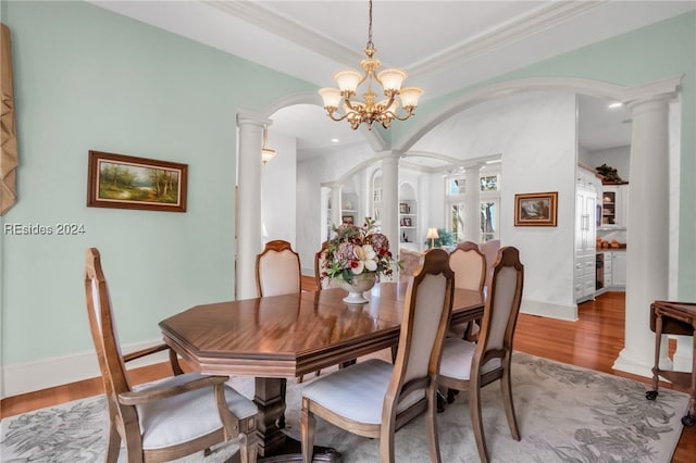 dining space featuring ornate columns, ornamental molding, light hardwood / wood-style flooring, and built in shelves