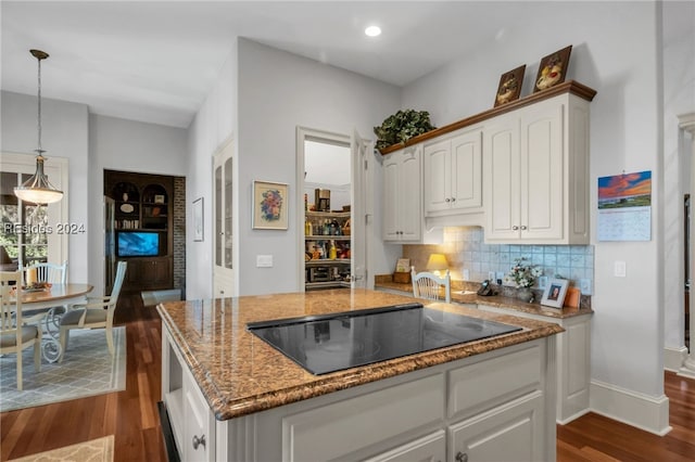 kitchen featuring light stone counters, tasteful backsplash, decorative light fixtures, black electric stovetop, and white cabinets